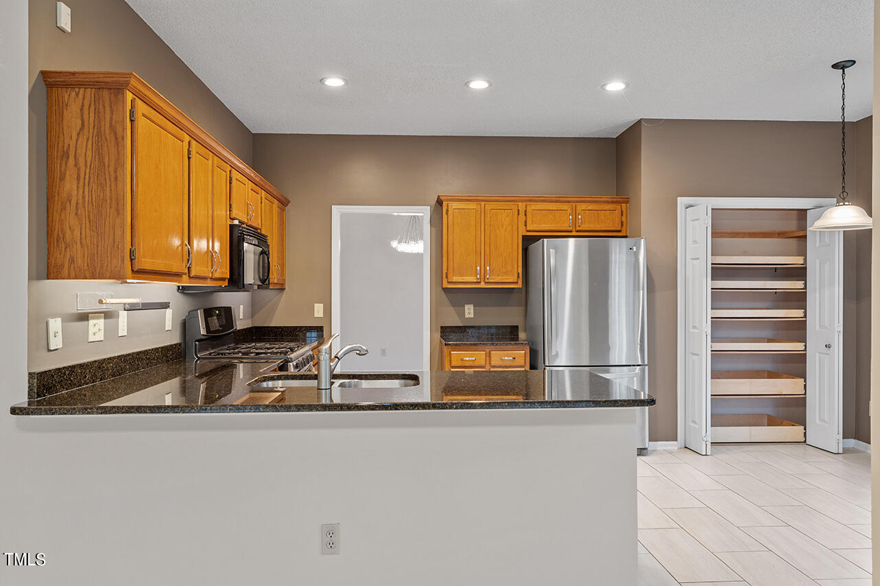 11932 North Exeter Way Raleigh, NC 27613 - Photo 18 of 35 a kitchen with stainless steel appliances a refrigerator and stove