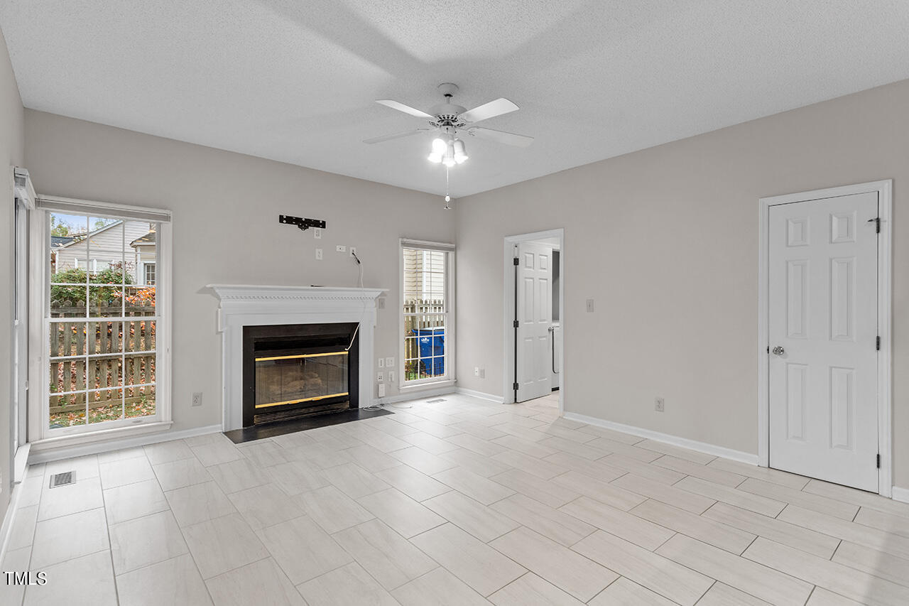 11932 North Exeter Way Raleigh, NC 27613 - Photo 22 of 35 a view of an empty room with a fireplace and a window