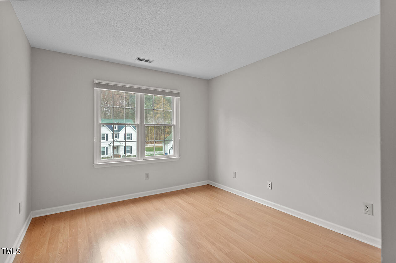 11932 North Exeter Way Raleigh, NC 27613 - Photo 35 of 35 an empty room with wooden floor and windows