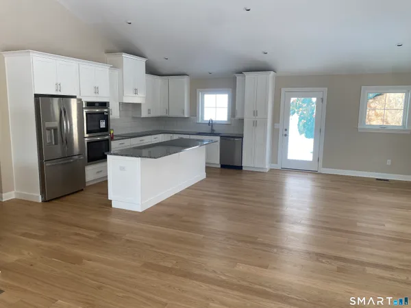 a kitchen with granite countertop a refrigerator and a stove top oven