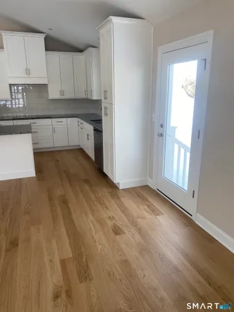 a view of a kitchen with wooden floor and electronic appliances