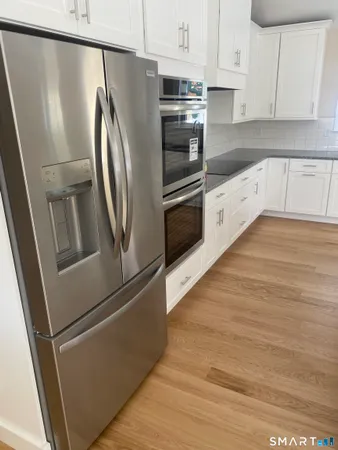 a kitchen with stainless steel appliances and wooden floor