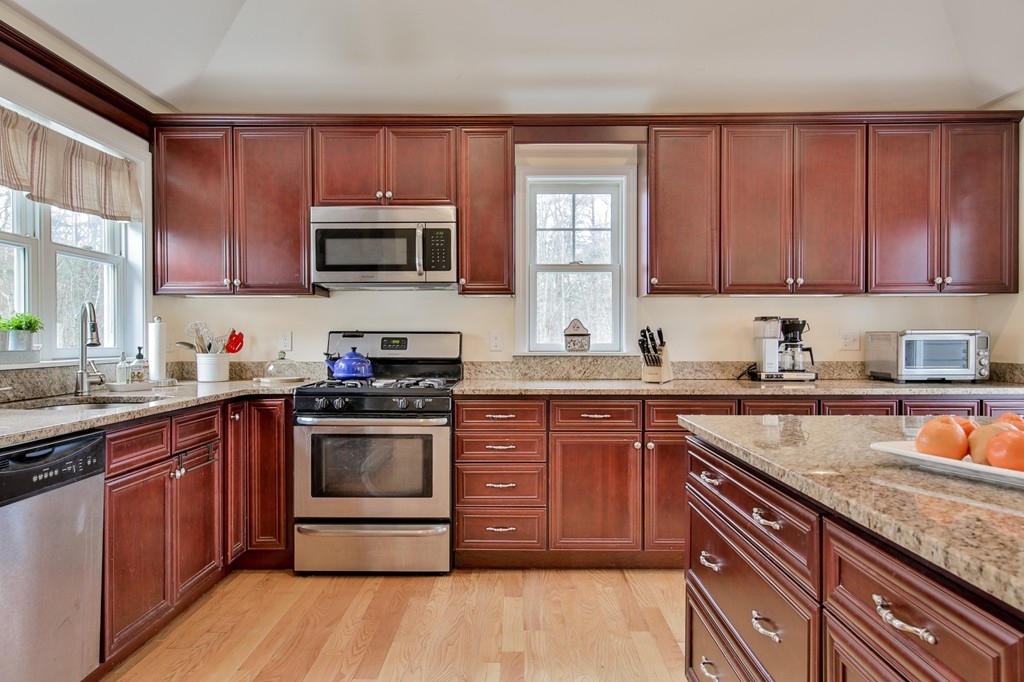 3 Erin Road Amesbury, MA 01913 - Photo 11 of 29 a kitchen with granite countertop wooden cabinets stainless steel appliances a sink and a window