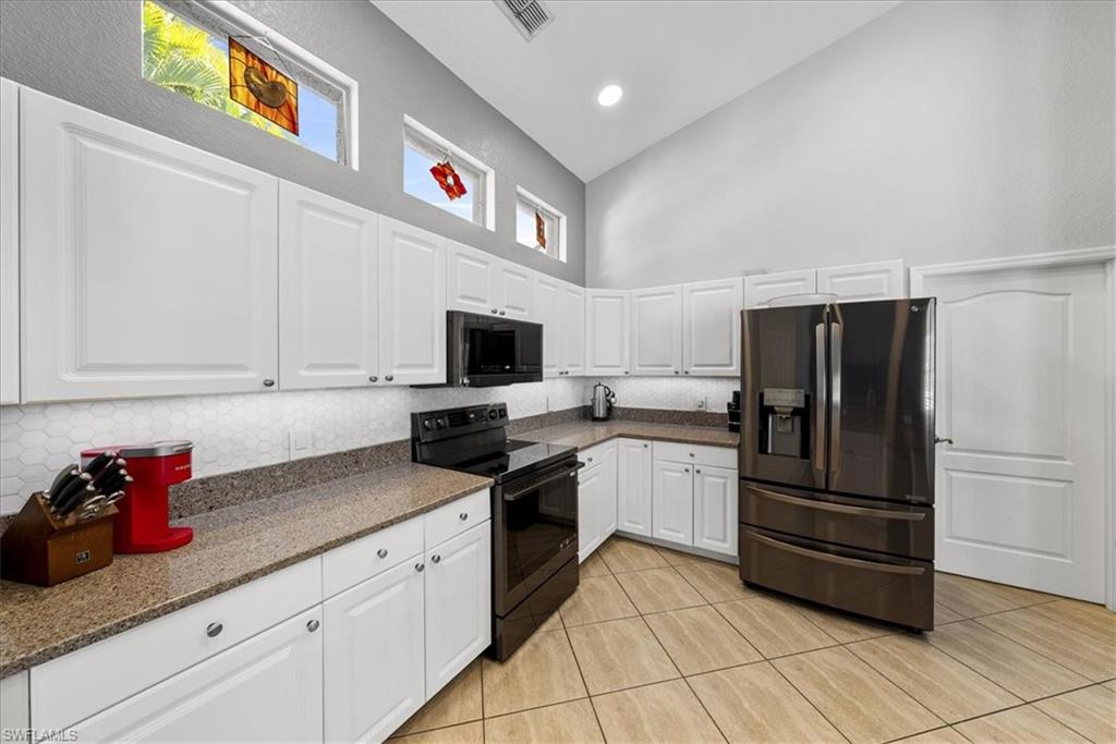 297 Sawgrass Court Naples, FL 34110 - Photo 15 of 31 a kitchen with stainless steel appliances granite countertop a refrigerator and a stove top oven
