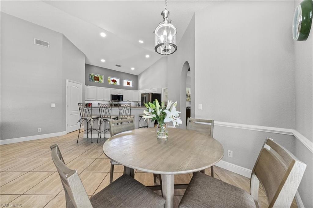 297 Sawgrass Court Naples, FL 34110 - Photo 16 of 31 a view of a dining room with furniture and wooden floor
