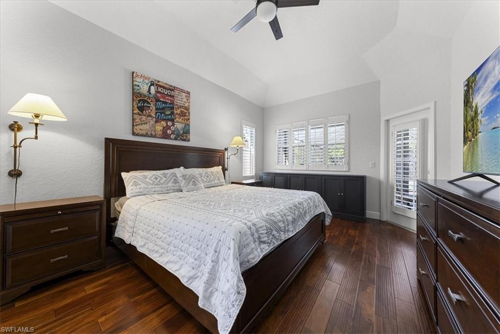 297 Sawgrass Court Naples, FL 34110 - Photo 17 of 31 a bedroom with a bed and a chandelier