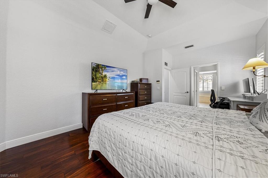 297 Sawgrass Court Naples, FL 34110 - Photo 18 of 31 a bedroom with a bed and a flat tv screen on dresser