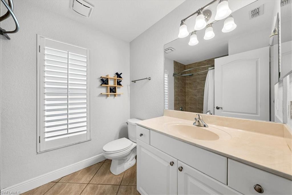 297 Sawgrass Court Naples, FL 34110 - Photo 22 of 31 a bathroom with a sink a toilet and a large mirror