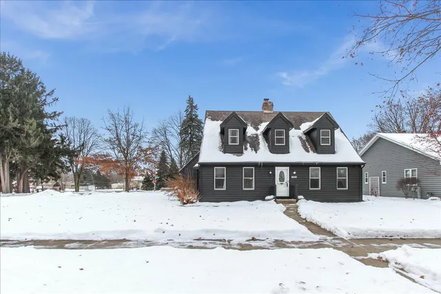 a view of a white house with a snow on the road