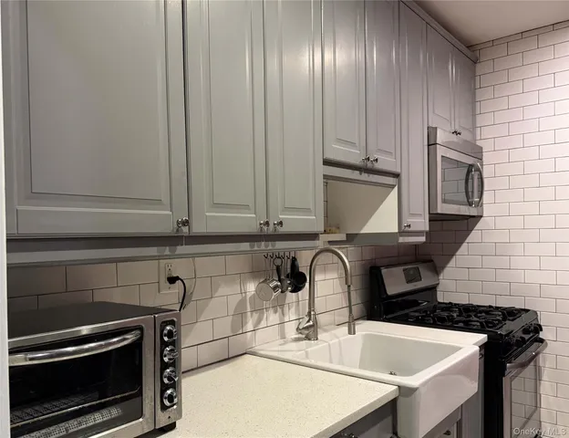 a kitchen with granite countertop a sink stainless steel appliances and cabinets
