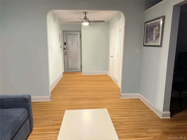 a view of a hallway with wooden floor and closet