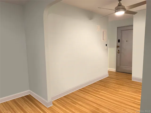 a view of empty room with wooden floor