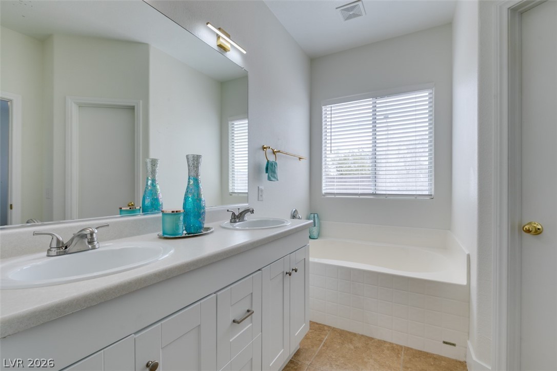 10959 Pumpkin Ridge Avenue Las Vegas, NV 89135 - Photo 29 of 51 Gorgeous well-appointed bathroom features a double vanity and a built-in tub with a window.