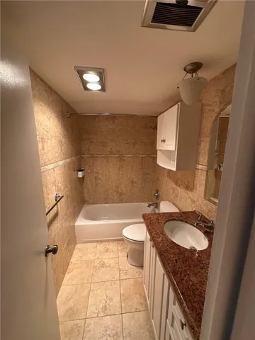 a bathroom with a sink a toilet a mirror and bathtub