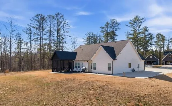 a view of a house with backyard and sitting area