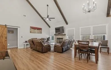 a kitchen with stainless steel appliances a sink a stove a refrigerator cabinets and a dining table