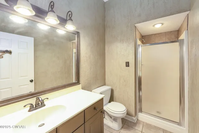 a bathroom with a sink a toilet a mirror and shower