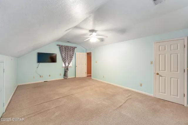 a view of empty room with a ceiling fan and window