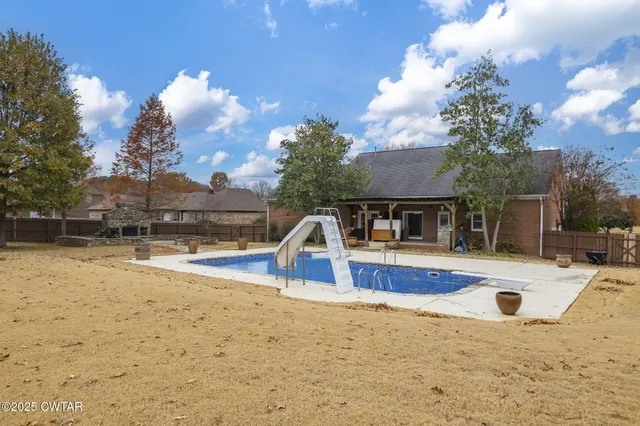 a view of a swimming pool with a yard