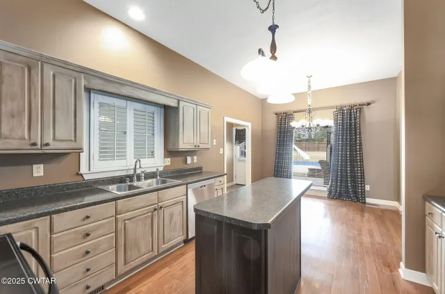 a kitchen with granite countertop a sink cabinets and wooden floor