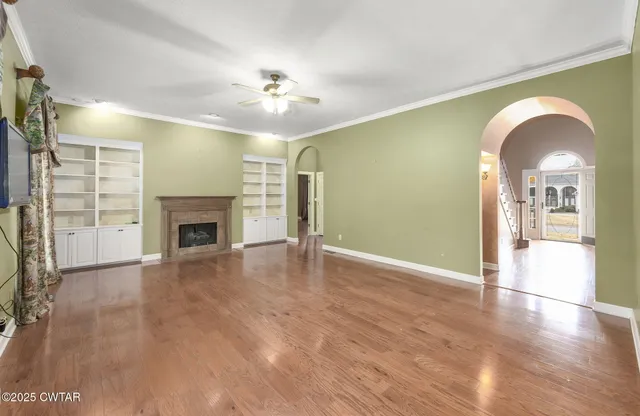 a view of an empty room with window and wooden floor