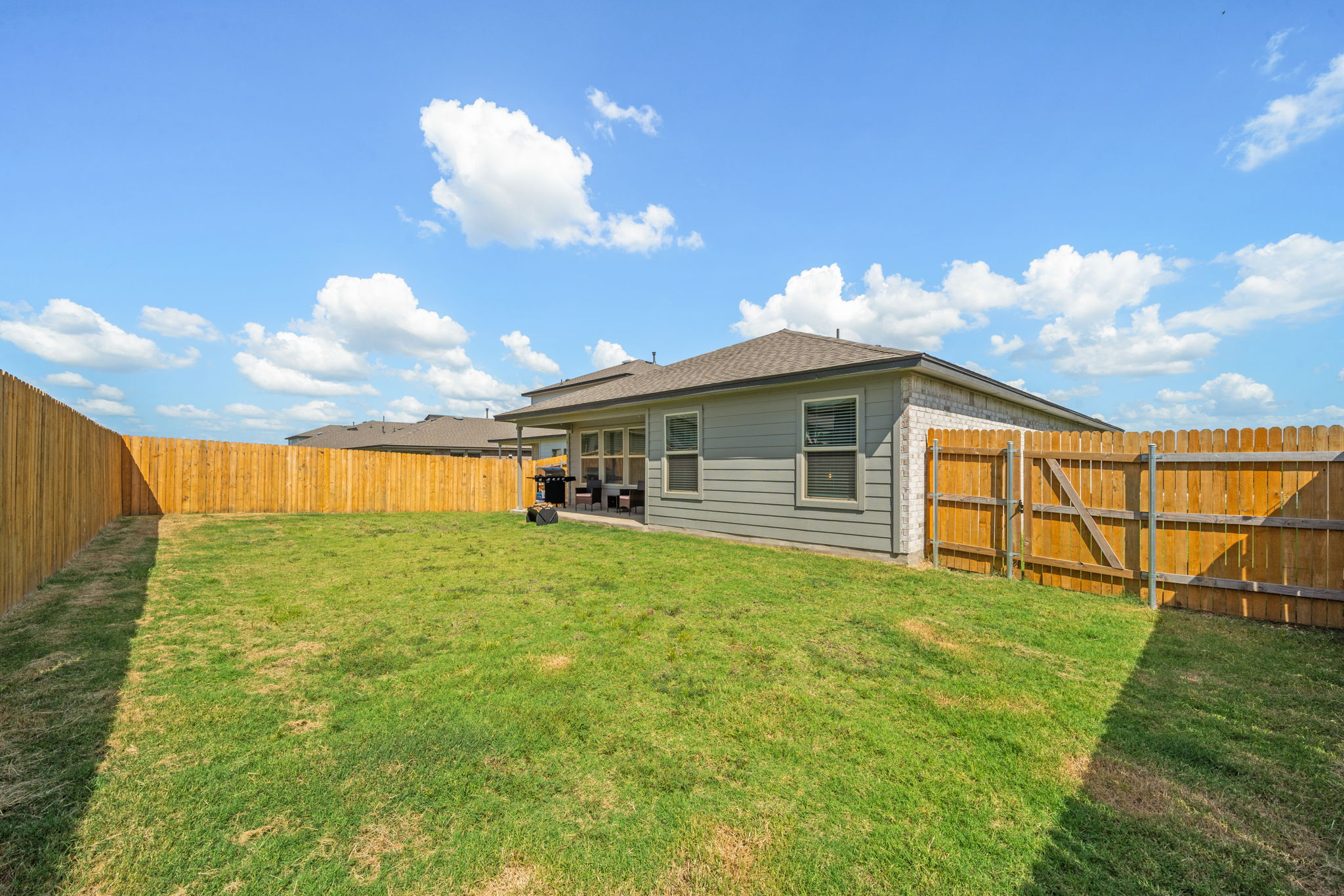 1117 Tipton Street Georgetown, TX 78633 - Photo 39 of 40 Spacious backyard featuring a full perimeter wooden privacy fence and a covered patio area