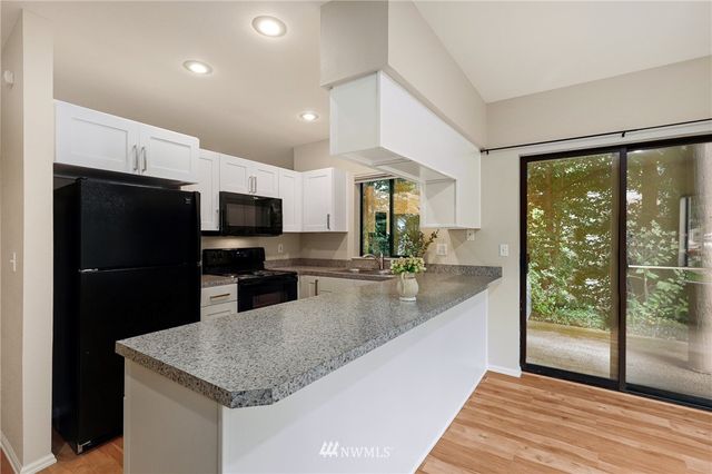 a view of a dining room with furniture large windows and wooden floor