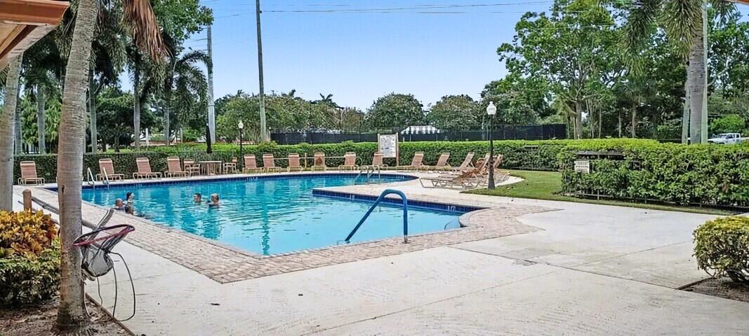 2791 Village Boulevard, Unit 105 West Palm Beach, FL 33409 - Photo 10 of 16 a view of a lake with a bench and chairs