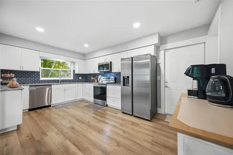 a kitchen with granite countertop a refrigerator and a sink