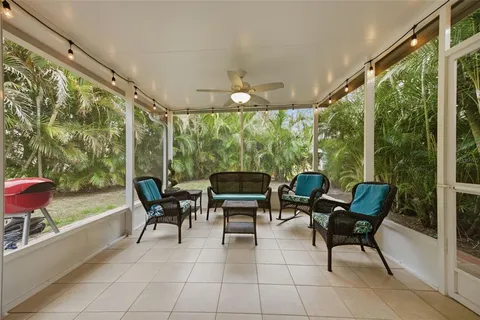 a living room with patio furniture and a floor to ceiling window