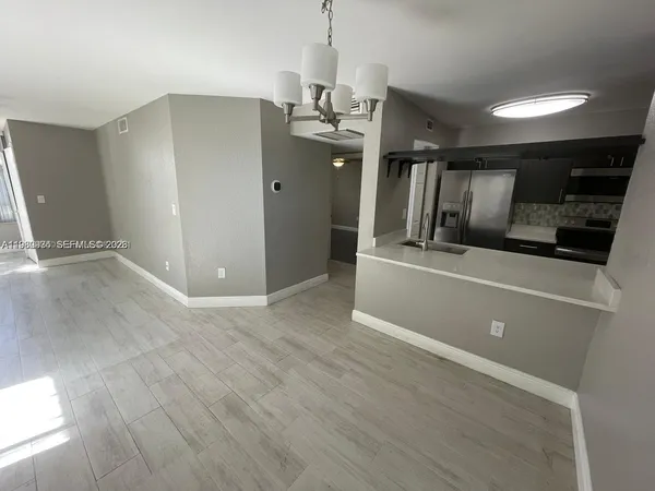 wooden floor in an empty room with kitchen