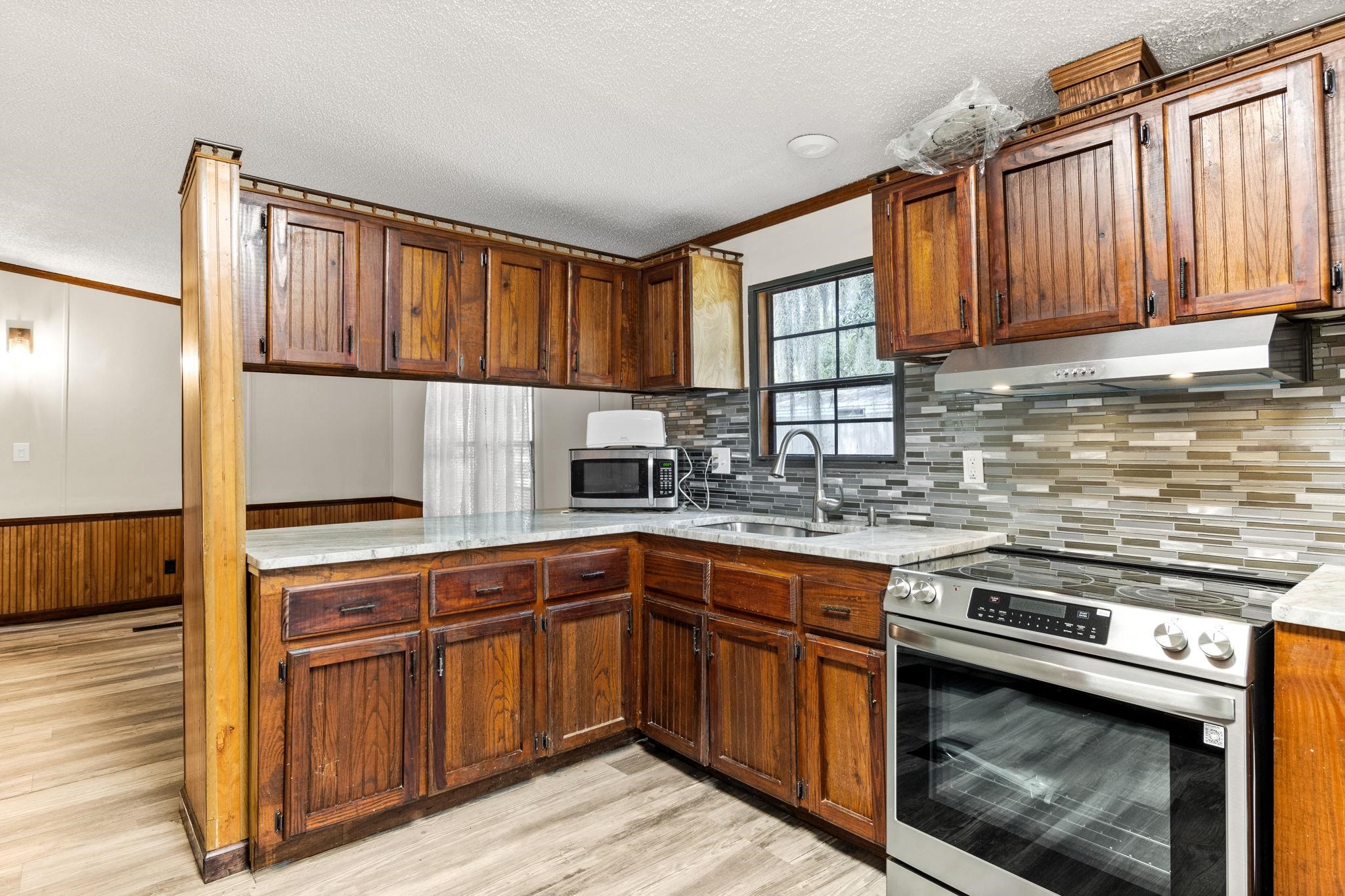 890 Kings Estate Road St. Augustine, FL 32086 - Photo 1 of 38 a kitchen with stainless steel appliances granite countertop wooden cabinets a sink and a stove