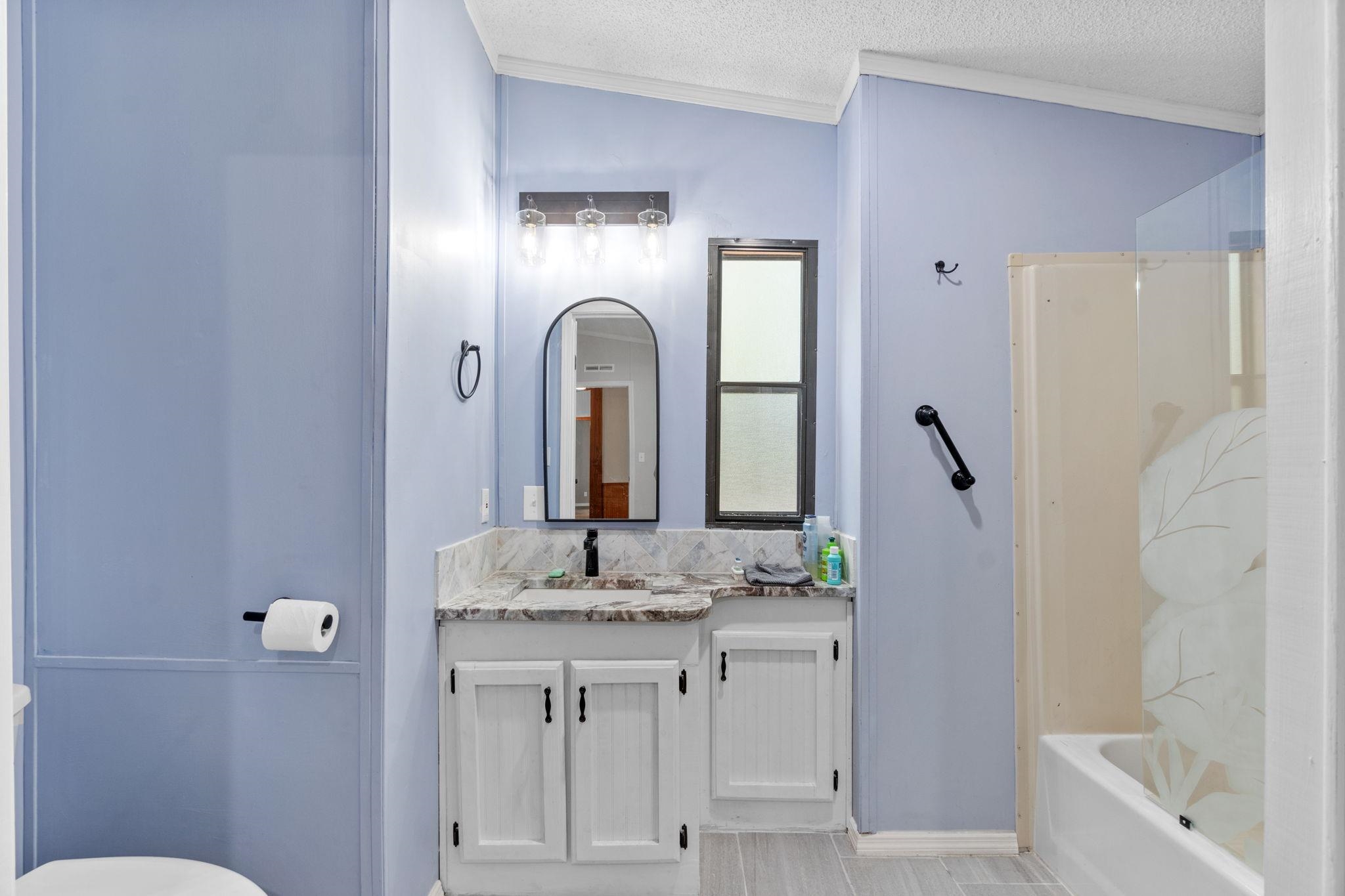 890 Kings Estate Road St. Augustine, FL 32086 - Photo 27 of 38 a en suite bathroom with a granite countertop sink and a mirror