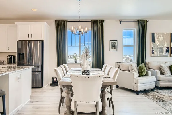 a dining room with furniture a chandelier and kitchen view