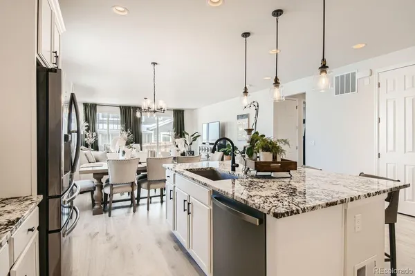 a kitchen with kitchen island granite countertop a table chairs stove and kitchen view