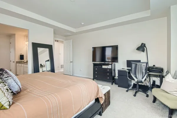 a bedroom with a bed a chair and flat screen tv