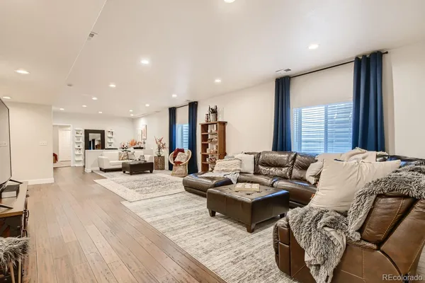 a living room with furniture wooden floor and a large window