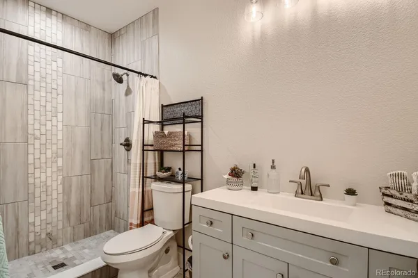 a bathroom with a sink a toilet and shower