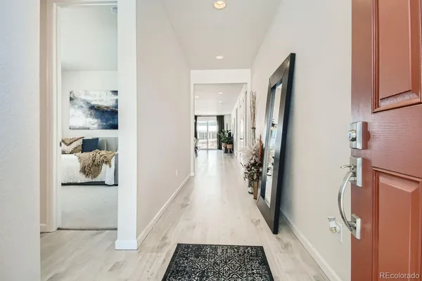 a walk in closet with wooden floor
