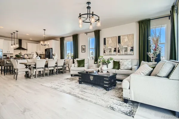 a living room with furniture kitchen view and a large window