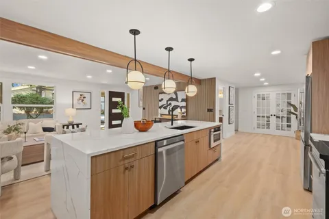 a large kitchen with kitchen island a large island a sink stainless steel appliances and cabinets