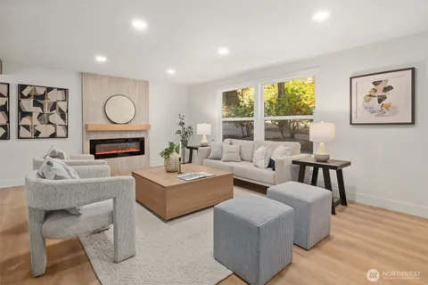 a living room with furniture a large window and a fireplace