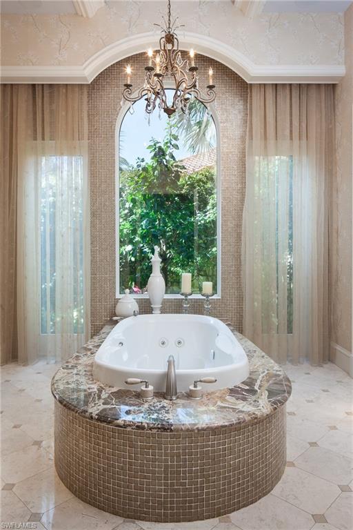 2152 Canna Way Naples, FL 34105 - Photo 23 of 25 a living room with a large window and chandelier