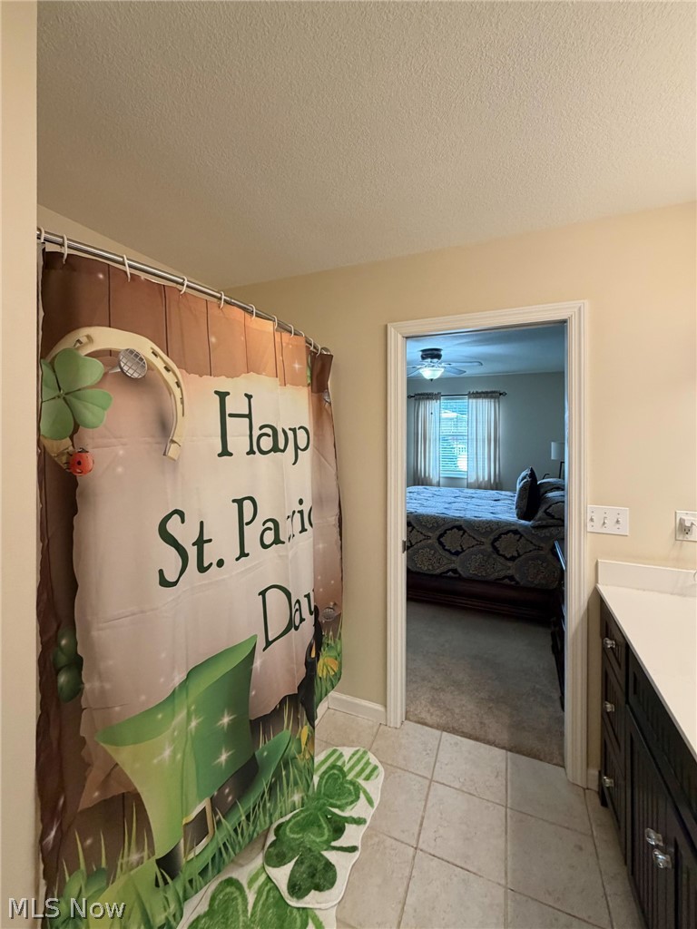 1343 Courtland Road Weirton, WV 26062 - Photo 26 of 50 Ensuite bathroom featuring vanity, a textured ceiling, curtained shower, and light tile patterned flooring