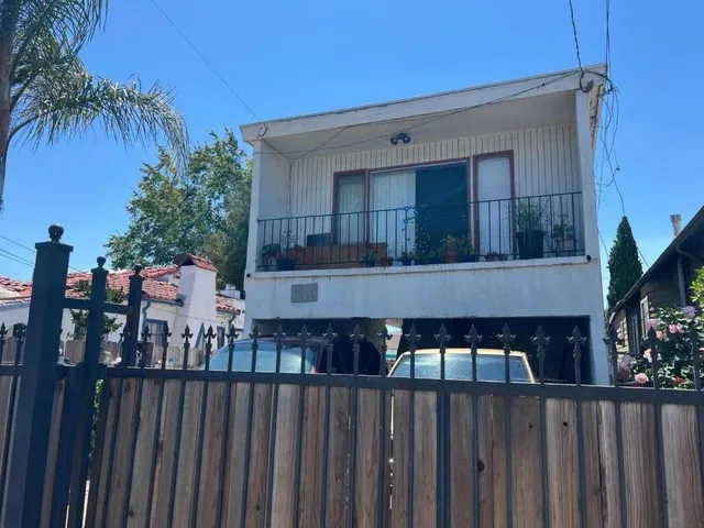 a view of a house with wooden fence