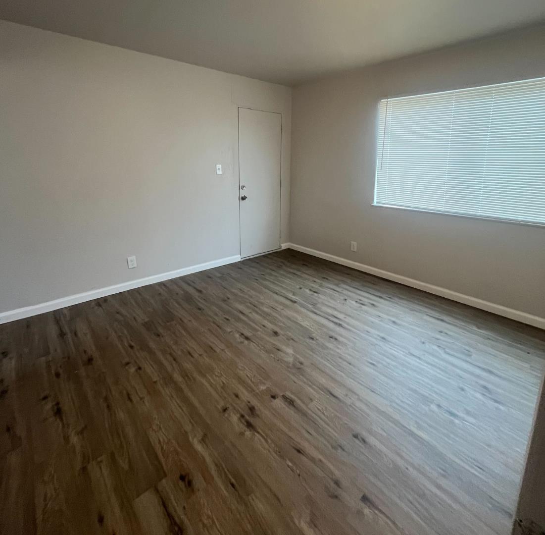 8707 A Street Oakland, CA 94621 - Photo 7 of 10 a view of an empty room with wooden floor and a window