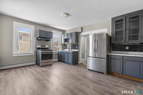 a kitchen with stainless steel appliances a refrigerator sink and cabinets