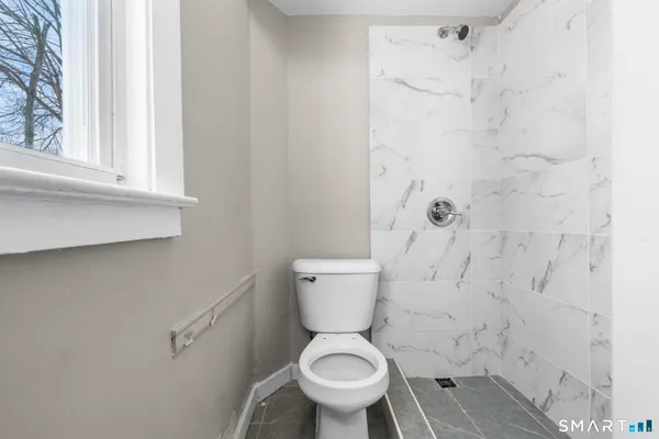 a white toilet sitting next to a window
