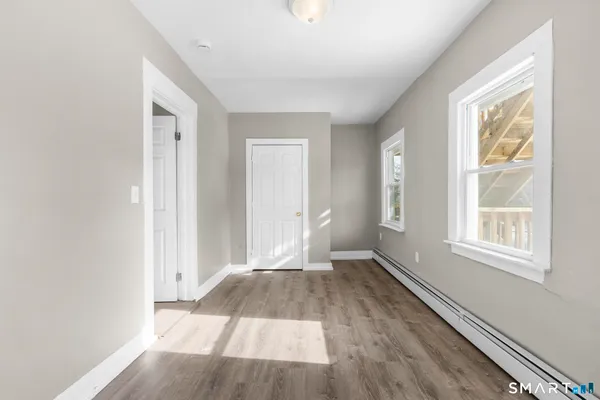 an empty room with wooden floor and windows