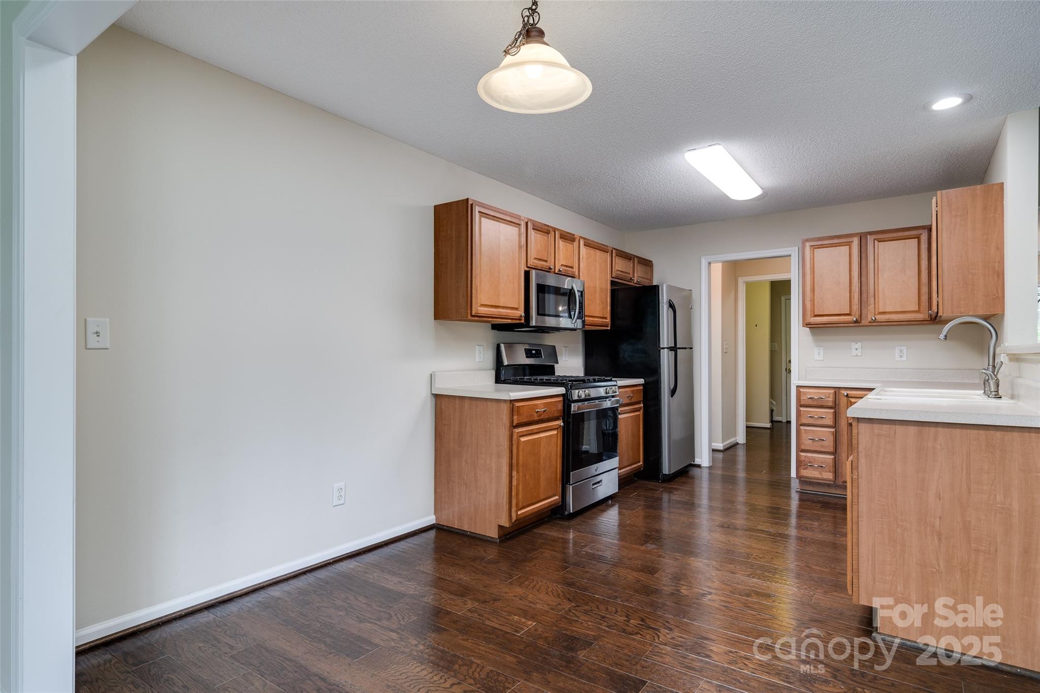 395 Running Briar Road Fletcher, NC 28732 - Photo 12 of 33 a kitchen with stainless steel appliances granite countertop a stove a sink a refrigerator white cabinets and wooden floor
